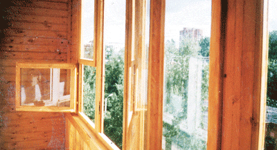 Установлены деревянные балконные рамы и окна. Какие-то распахнуты. Открыта форточка. Видна обшивка деревянной вагонкой.