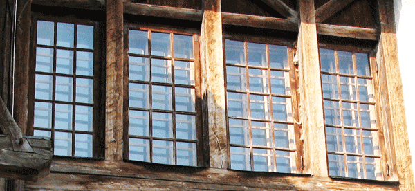 Двойные окна с переплётом в старинном стиле. Покрашены полупрозрачной коричневой пропиткой, визуально старящей дерево.